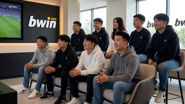 一群多元的体育迷在带有bwin必赢品牌标识的现代体育观赏休息区通过大屏幕一起观看直播比赛