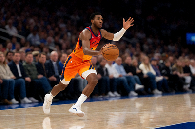 NBA比赛中球员突破上篮的瞬间,球场灯光明亮,观众席背景虚化