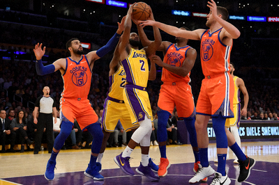 NBA比赛现场，洛杉矶湖人在主场对阵金州勇士，场上球员激烈争夺